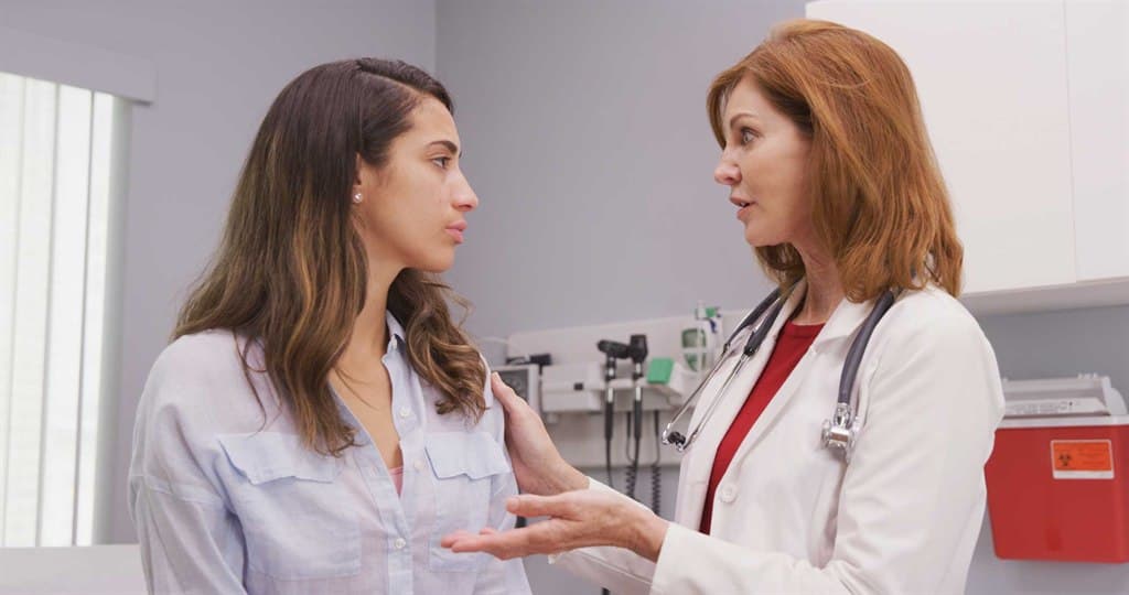 Una doctora habla con una paciente en una sala de consulta