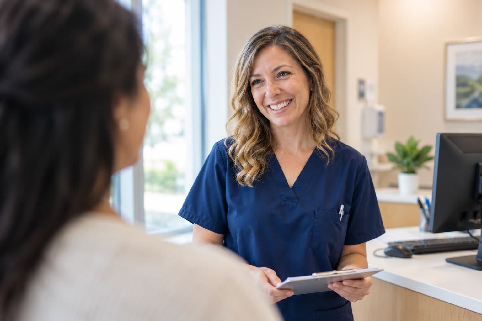 A smiling provider talking with a patient in a bright office