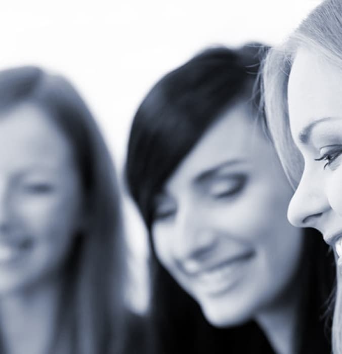 Three women standing together, smiling